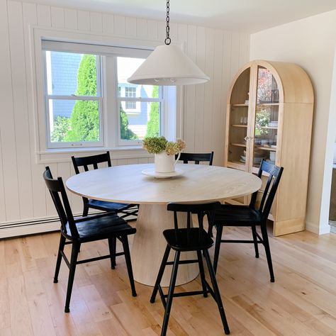 The neutral dining nook of my dreams includes vertical shiplap, an arched cabinet, cerused oak pedestal table, black Windsor chairs and a concrete plaster pendant complete with a tiny matching chair for my littlest. Follow my shop Penny&PearlDesign on the @shop.ltk app to shop this post and get my exclusive app-only content! #liketkit #LTKhome #LTKfamily #LTKstyletip @ltk.home #diningnook #diningroom #diningtable #diningroomdecor #diningroominspo #idcoathome #howihaven #smmakelifebeautiful #s White Oak Round Table, Pedestal Table And Chairs, Black Windsor Chairs, Oak Pedestal Table, Pedestal Kitchen Table, Arched Cabinet, Vertical Shiplap, Black Chairs, Windsor Chairs