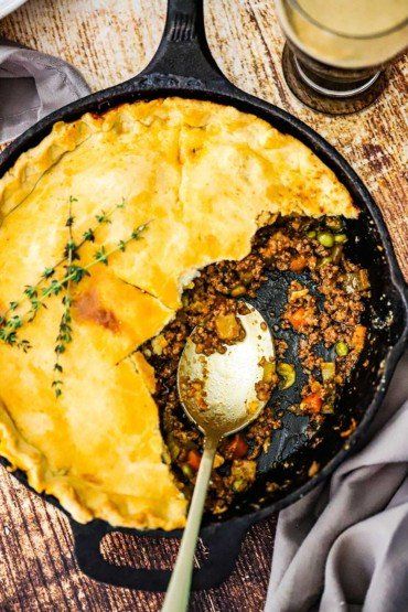 An overhead view of a Guinness ground beef pot pie in a cast iron skillet with half of the crust gone and a spoon inserted in the meat and vegetable filling. Ground Beef Pot Pie, Beef Pot Pie, Easy Shepherds Pie, Beef Pot Pies, Beef Pies, Cooking With Beer, Shepherds Pie Recipe, One Pot Dinner, American Heart Association