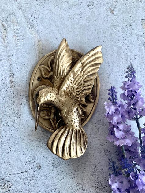 This exquisite Brass bird-shaped door knocker is the perfect addition to your door, giving it a distinct and remarkable look. The knocker and the plate are meticulously crafted with intricate details, showcasing the exceptional craftsmanship of the artist.  This door knocker is not just a beautiful work of art, but also a testament to its exceptional quality and durability. It's made to last, withstanding the test of time, making it an ideal gift for your loved ones. Product measurement details: Gold Front Door, Front Door Knocker, Brass Animals, Brass Bird, Flying Bird, Door Knocker, Home Upgrades, Door Knockers, Dream Decor