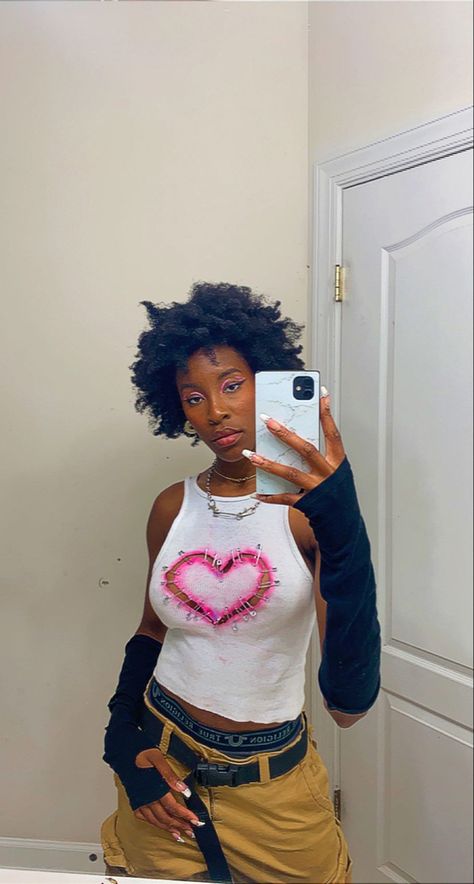 Black girl with afro posing in mirror with a white shirt that has a heart in the middle attached to the shirt with safety pins Safety Pin T Shirt Diy, Safety Pin Heart Shirt, Diy Grunge Shirt Ideas, Diy Shirt Aesthetic, Safety Pin Shirt Diy, Punk T Shirt Diy, Grunge Shirt Diy, Diy Grunge Shirt, Ways To Cut Shirts Diy