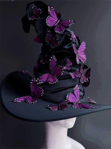 Transform your Halloween costume into a bewitching masterpiece with our black witch hat. This hat is adorned with beautiful purple butterflies that dance in the moonlight, adding an enchanting touch to your look. Whether you're brewing potions, casting spells, or just looking to turn heads, this hat will add an extra layer of magic to your ensemble. Age Group/Gender - Adult/Unisex Size/Type - One size fits all adults Hat Base Color - Black Hat Material - Fabric Witch Hat Alternative, Unique Witch Hat, Witch Costumes Purple, Unique Witch Hats, Purple Hair Witch Costume, Butterfly Witch Costume, Cool Witch Hats, Black Butterfly Costume, Woodland Witch Hat