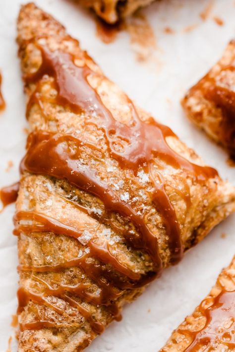 Caramel Apple Turnovers are a fall dream! A tender, caramely, spiced apple filling is wrapped up in a blanket of golden brown, flaky puff pastry and topped with salted caramel sauce. These apple turnovers shine in any situation -  whether it's a casual afternoon baking session, or a holiday celebration! #appleturnovers #caramelapple #saltedcaramel #applerecipes #appledesserts #falldesserts #fallbaking #easydessertrecipes #easydesserts #bluebowlrecipes | bluebowlrecipes.com Puff Pastry Apple Turnovers, Peach Turnovers, Pastry Photography, Puff Pastry Apple, Apple Puff Pastry, Quick Lunch Recipes, Caramelised Apples, Apple Turnovers, Caramel Recipes Sauce