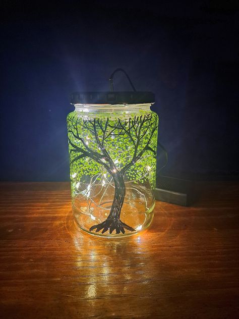 Perfect for virtually any style of living room, bedroom, or dorm, this handmade fairy light lamp is created with upcycled glass and oil-based paint. It's even perfect for a guy! Features a hand-painted green leafy tree with curling tendrils backlit by ambient fairy lights to set a dreamy mood in your living space! Because the art is hand-drawn, each jar is unique and no two are exactly alike.  Because they are crafted from upcycled materials, the jars I use may vary in brand, style, and sizing. Glass Jar Lamp, Spooky Bedroom Decor, Fairy Light Lamp, Spooky Bedroom, Firefly Painting, Fairy Lights In A Jar, Halloween Bedroom Decor, Halloween Bedroom, Handmade Fairy