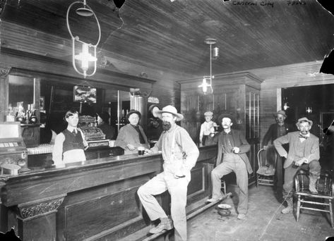 Saloon scene, Central City, Colorado (1870s). Interesting elements: spittoons, kerosene lights, slot machine at left, young boy at the end of the bar, working class clientele, Green River advertisement. Courtesy of Denver Public Library Central City Colorado, Old Tavern, Cowboy Town, Saloon Bar, Old West Saloon, Old West Photos, Western Saloon, Frederic Remington, Real Cowboys