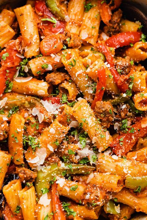 This pasta dish is one of our all-time favorite weeknight meals! It's made with plenty of roasted bell peppers and tomatoes, with some getting blended into a sauce for extra heartiness. Toss your veggies and rigatoni together with plenty of sausage, sauce, and parmesan cheese for an easy and impressive dinner everyone will love! #rigatoni #weeknightpasta #roastedredpeppers #bellpeppers #italiansausage #easydinnerrecipes #mealpreprecipes #bluebowlrecipes | bluebowlrecipes.com Roasted Bell Pepper Pasta, Rigatoni Sausage, Bell Pepper Pasta, Rigatoni Pasta Recipes, Burst Tomatoes, Roasted Bell Peppers, Sausage Parmesan, Rigatoni Recipes, Sausage Sauce