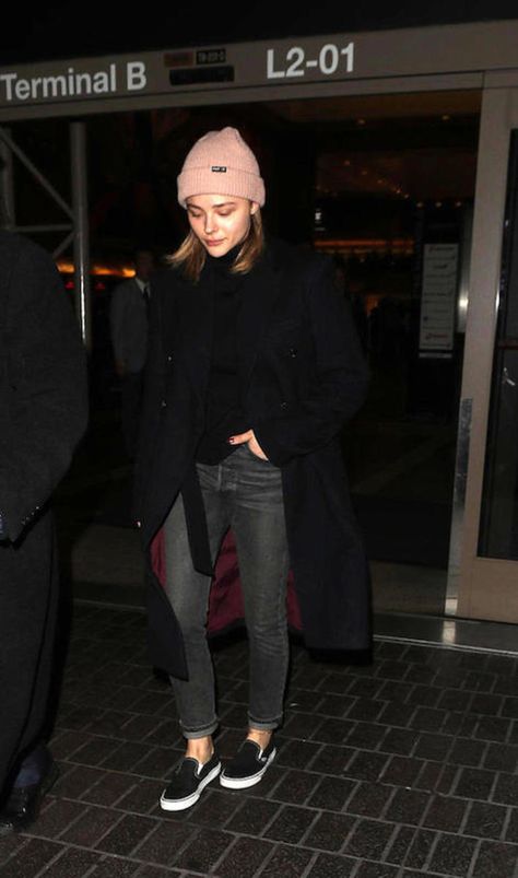 Chloe Moretz wearing a blush pink knit beanie hat, black sweater, long black coat, gray straight leg jeans, and black Vans slip on sneakers Black Slip On Outfit, All Black Vans Outfit, White Slip On Vans Outfit, Black Slip On Vans Outfit, Black Vans Outfit, Slip On Outfit, Vans Slip On Black, Chloe Grace Mortez, Beanie Outfit