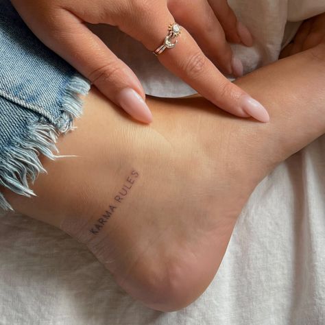 Harry Styles Ankle Tattoo, Karma Rules Tattoo Harry Styles, Karma Rules Tattoo, Karma Tattoo Design, Harry Styles Inspired Tattoos, Tattoo Karma, Back Of Ankle Tattoo, Heel Tattoos, Tattoos Ankle