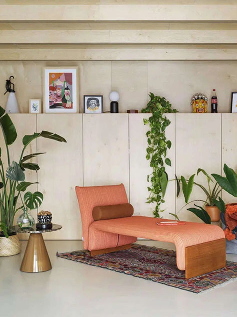 A curved, green upholstered bench with rolled arms and cylindrical bolsters, featuring a low profile and tapered metal legs. The bench is placed in front of a white wall adorned with a large, abstract hanging artwork featuring bold colors and geometric shapes. Conversations With Friends, Waiting Area, The Bedroom, Public Space, Modern Furniture, Contemporary Design, Interior Decorating, Dreaming Of You, Bench