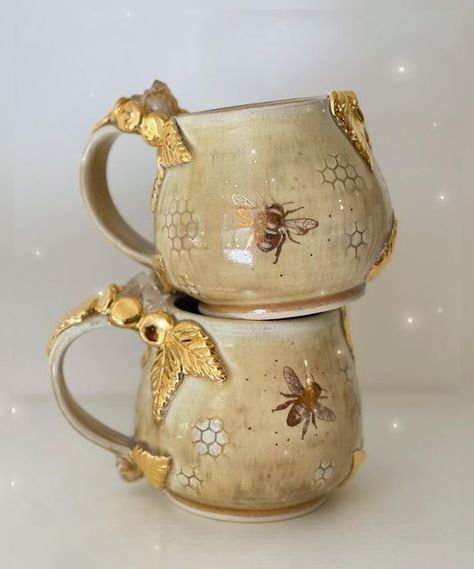 Lauren Lewis on Instagram: "These mugs are begging to be used for a cup of hot tea with honey as the weather turns cool. 🍂🍯🐝 . . . #clay #handmadehome #honeybee #potterymaking #pottery #ceramicart #ceramic #honeycomb #bees #beeswax #beekeeping #beeart #artistsupport #intentionalart #designinspo #honey #honeybees #cottagecore #boho #crystals #citrine #cottagecoreaesthetic #quartz #cottagegarden #maker #naturewitch #witchyvibes #mug" Bee Clay Mug, Ceramic Bee Mug, Honey Comb Pottery, Bee Hive Pottery, Bee Ceramics Pottery, Beehive Pottery, Cottagecore Ceramics, Ceramic Bees, Bee Ceramics