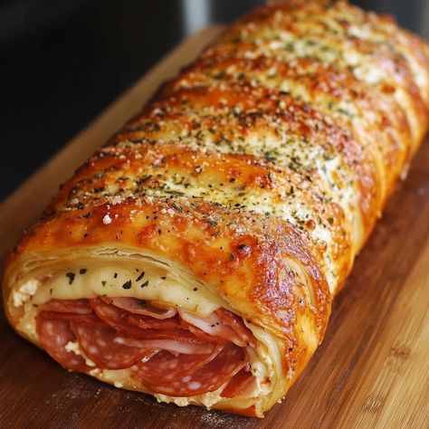 Italian Stromboli  ￼  1 tube of pillsbury pizza crust 8 slices of deli ham 10 slices of Genoa salami 12 slices of sandwich pepperoni 8 slices provolone cheese or mozzarella (You could definitely use shredded cheese as well) 2 tablespoons of butter 2 minced garlic gloves 2 teaspoons chopped parsley 3 tablespoons of Parmesan cheese Melt the butter in the microwave and mix in the minced garlic, parsley and Parmesan cheese. Set aside I lined my baking sheet with parchment paper. Stretch the pizza crust out to almost the size of your baking sheet. Layer the deli meats. I started with the ham, then the salami followed by the pepperoni. Layer the cheese last. Roll the Stromboli longwise and be sure to seal the seam good. Seal the ends good. Pinch them and mold the excess dough to the underside of Pillsbury Pizza Crust Recipes, Stromboli Italian, Pillsbury Pizza Crust, Italian Stromboli, Pillsbury Pizza, Stromboli Recipe Easy, Rita Recipe, Homemade Stromboli, Stromboli Recipe