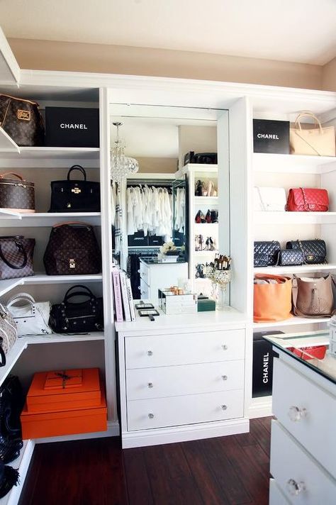 Organized, glam closet features beige walls holding mounted wraparound bag shelves accented with orange Hermes boxes and black Chanel shopping bags flanking a built in white dresser finished with round glass pulls sat below a large mirror. Bag Shelves, Transitional Closet, Glam Closet, Closet Features, Chanel Shopping, Bag Closet, Organization Closet, Dream Closet Design, White Dresser