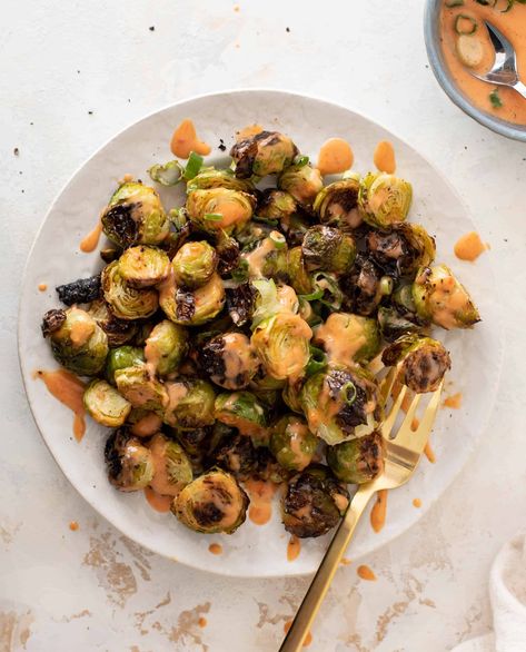 These bang bang brussels sprouts are crispy and delicious. Roasted until perfection, the brussels are charred and drizzled with a creamy garlicky chili sauce that adds the perfect element of flavor. Seriously addictive and poppable! Bang Bang Brussel Sprouts, Meatless Main Dishes, Meatless Dinner, Veggie Side Dishes, Vegetable Sides, Side Recipes, Veggie Sides, Veggie Dishes, Brussels Sprouts