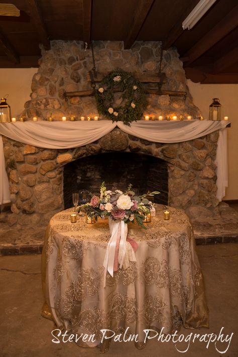 Rustic Tucson wedding at Corona Ranch. Desert Dove theme - plum, mauve, sage, gray. Rustic and romantic head table and mantle decor with drapping, tea lights, succulent wreath and lanterns.  Tucson wedding florist design by A Floral Note. Vendella and Amnesia roses, peonies, succulents, snapdragons, acacia, eucalyptus, olive, astrantia, dusty miller,  & majolika spray roses.    Design by POM Events. Photos by Steven Palm Photography. Floral design by A Floral Note. Mantle Decorating Ideas Wedding, Mantel Decorating Ideas Wedding, Wedding Fireplace Mantle Decor, Wedding Mantle, Palm Photography, Wedding Fireplace, Tucson Wedding, Fireplace Mantle Decor, Florist Design