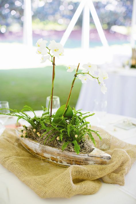 Boat-Themed Centerpiece Boat Wedding Centerpieces, Boat Centerpiece Ideas, Canoe Centerpiece, Lake Party Decorations, Fishing Centerpieces Ideas, Orchid Beach Wedding, Fishing Centerpieces, Boat Wedding Decorations, Kourtney Wedding