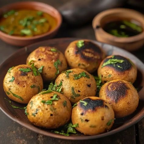 Litti Chokha is a traditional and beloved dish from the Indian state of Bihar. It is a rustic, flavorful, and wholesome meal that consists of round wheat flour balls called "litti" served with a spicy and tangy mashed vegetable preparation known as "chokha." Litti is roasted over an open flame or in a tandoor, giving it a smoky flavor, while chokha is made by mashing roasted or boiled vegetables. This combination of Litti and Chokha is not only delicious but also a staple of Bihari cuisine. Liti Chokha, Bihari Cuisine, Litti Chokha Recipe, Litti Chokha Bihar, Chokha Recipe, Chikar Cholay Recipe, Khichuri Bengali, Litti Chokha, Litti Chokha Street Food