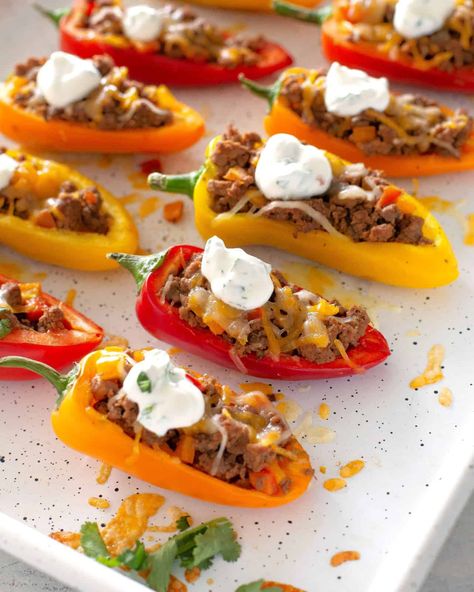 Mini Taco Stuffed Peppers stuffed with taco meat, cheese, and drizzled with a cilantro cream sauce. #mini #taco #stuffed #peppers #recipe Taco Stuffed Mini Peppers, Stuffed Mini Peppers With Ground Beef, Mini Peppers Stuffed With Cream Cheese, Mini Bell Pepper Recipes, Cilantro Cream Sauce, Aldi Meals, Apps Ideas, Ground Turkey Stuffed Peppers, Bariatric Meals