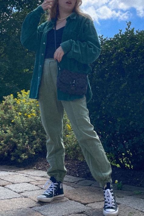 Woman standing outside on a cobblestone path wearing black high-top converse, green cargo pants, a black tank top, pearl necklace and green corduroy jacket with a black Coach crossbody bag Dark Green Corduroy Jacket Outfit, How To Style Green Corduroy Jacket, Green Coudroy Jacket Outfits, Converse Casual Outfit, Corduroy Aesthetic, Corduroy Jacket Cropped, Vintage Button-up Corduroy Outerwear, Aesthetic Converse, Green Monochrome