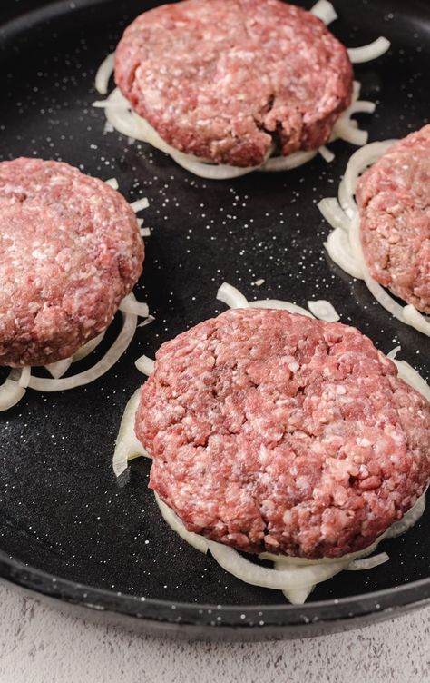 ground beef patties on top of cut onions on a skillet Deep Fried Burger Patty, Oklahoma Fried Onion Burger Pioneer Woman, Pan Fried Hamburger Patties, Fried Hamburger Patties, Pan Fried Hamburgers, Burger Dip, Fried Onion Burger Recipe, Oklahoma Onion Burger, Hamburger Sandwiches