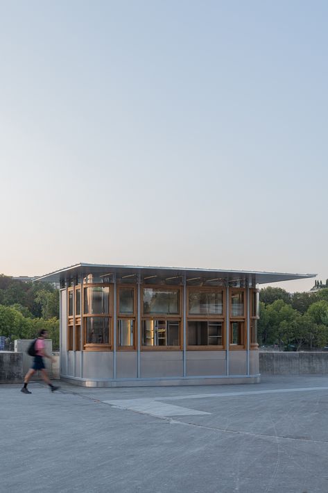 The Franklin Azzi agency revamped the conception of a food stand at the base of the Eiffel Tower. Situated in heart of one of Paris’ most remarkable heritage sites, this project posed the challenge of integrating a new micro-architecture design into a dense and singular context. Cafe Architecture, Kiosk Design Ideas Architecture, Industrial Kiosk Design, Market Pavilion Architecture, Cafe Pavilion Architecture, Pop Up Pavilion Architecture, Food Kiosk, Pavilion Architecture, Minimal Architecture