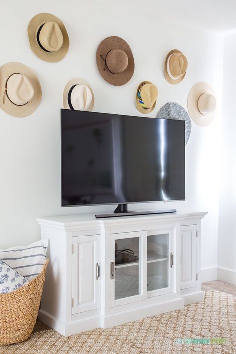 Cute idea for decorating around a TV. These beach hats are a fun way to add personality and memories to the wall! #bohodecor #coastaldecor #coastallivingroom Beachy Hats, Decorating Around A Tv, Coastal Styling, Staging Photos, French Country Farmhouse Decor, Tv Rooms, Painted Interior Doors, Life On Virginia Street, Den Ideas