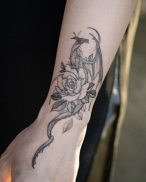 Dragon with flowers tattoo on wrist Dragon Tattoo Wrist, Dragon Tattoo With Flowers, Targaryen Tattoo, Tattoo With Flowers, Molecule Tattoo, Small Dragon Tattoos, Flower Wrist Tattoos, Dragon Tattoo For Women, Geniale Tattoos