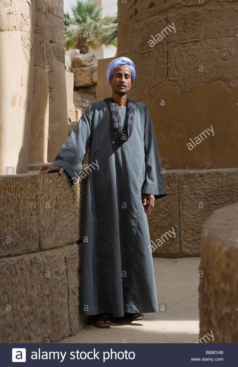 Download this stock image: Nubian man wearing traditional clothing, standing between columns, Karnak Temple, Luxor, Egypt, Africa - BB8CHB from Alamy's library of millions of high resolution stock photos, illustrations and vectors. Egyptian Clothing Men, Egyptian Traditional Clothing, Egypt Clothing, Elizabeth Peters, Egyptian Men, Egyptian Clothing, Egypt Culture, Karnak Temple, Luxor Egypt