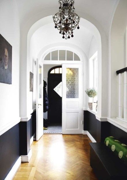 When clients ask about chair rails, I often suggest that they paint everything below it a glossy white so that it becomes more of an architectural element in the room. I also love how the crisp white looks against a really bold color on top.          (This photo is Conan O’Brien’s dining room, … Black And White Hallway, White Hallway, Chair Rail, Entry Hall, Hus Inspiration, Entry Way, The Ceiling, Style At Home, Wood Flooring