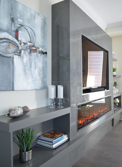 Condo fireplace wall featuring dark gray oversize tile around the fireplace & TV, with custom cabinetry on both sides. Floating shelves on the far right. Hidden drawers below the open cabinets on right and left. Fireplace is Dimplex XLF74 Ignite electric. Design/build by Stylish Fireplaces. Electric Fireplace Wall Ideas, Condo Fireplace, Fireplace Modern Design, Fireplace Feature Wall, Modern Electric Fireplace, Feature Wall Living Room, Electric Fireplace Wall, Condo Living Room, Fireplace Tv Wall