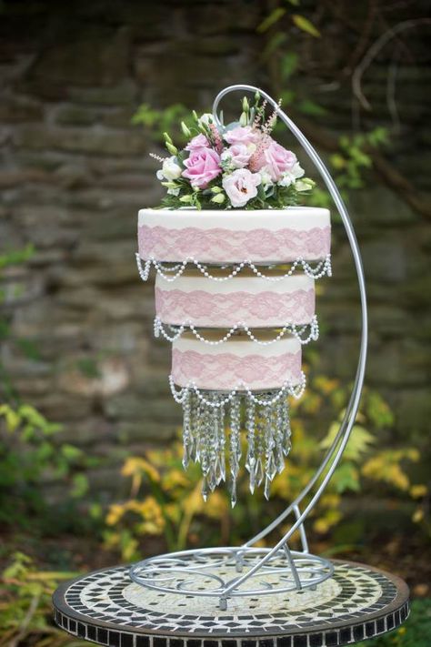 Pink lace & pearl chandelier wedding cake with hanging pendant Gluten-free & vegan Created by Ali at The Local Bakehouse www.thelocalbakehouse.com Flowers by Fiesta Flowers, Sandy Park Rd, Brislington, Bristol, UK Photo: Debbie Hudson Photography Hanging Cake Wedding, Wedding Cake With Stairs, Brislington Bristol, Chandelier Wedding Cake, Wedding Shower Centerpieces, Fiesta Flowers, Hanging Cake, Cake Flavours, Chandelier Cake