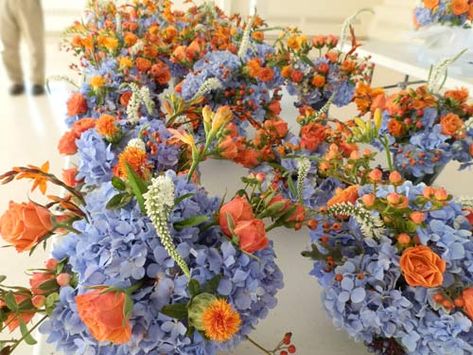 Blue And Orange Flower Centerpieces, Orange Blue Floral Arrangements, Blue Hydrangea And Orange Bouquet, Orange And Blue Wedding Decorations, Orange Blue Centerpiece, Blue Orange Floral Arrangement, Fall Blue And Orange Decor, Red Orange Blue Wedding, Blue White Orange Flower Arrangements