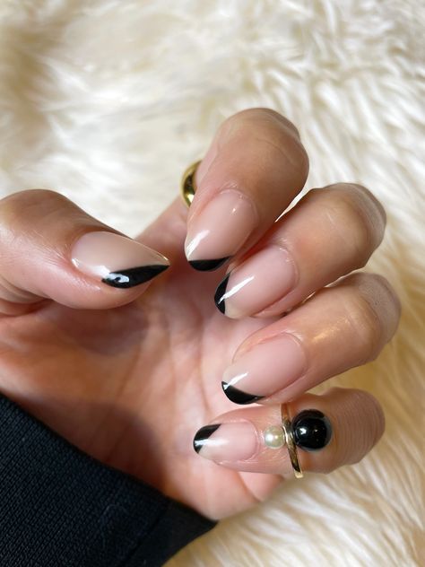 A nude base plus alternating angled black tips, made with regular polish and a striper brush