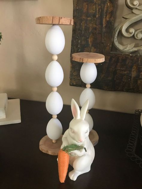 This easy egg candle holder is great to add some height to your Easter decor. I think it's the perfect additon and adds a great touch!Have a look below at how I made them and let me know what you think. What you’ll need:Plastic white eggsShish kebab skewersWooden beadsWood slicesDrillGlue gun Find the center point of the wood slice and drill a hole half way though. The hole needs to be large enough for the skewer to fit in. This piece will be your base. Drill through all of the Wooden Egg Craft Ideas, Diy Wooden Candle Stand, Diy Candlestick Holders Wood, Easter Candle Holders, Diy Egg Candler, Easter Table Centerpieces, Egg Candle, Rustic Easter Decor, Making Easter Eggs