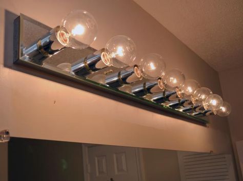 Is a dated bathroom light fixture making you look bad? See how easy it is to install new lighting over your bathroom mirror. Change Bathroom Vanity, Cheap Light Fixtures, Bathroom Light Bar, Vanity Lighting Over Mirror, Change Light Fixture, Bathroom Light Bulbs, Diy Bathroom Vanity, Mirror Makeover, Diy Light Fixtures