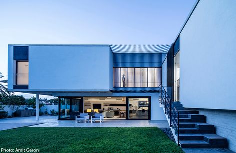 The facade of the modern house, painted in white and cladded with concrete strips, emphasize it’s horizontal direction. Iron slats provide shading and add to the sense of rhythm. Designed by Jacobs Yaniv Architects, photo by Amit Geron - Fineshmaker 200sqm House, House Luxury Modern, Modern House Philippines, Modern Facades, Home Gym Design Garage, Ideas For House, Paint For Kitchen Walls, Concrete Facade, Courtyard House Plans