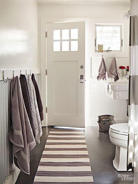 Charcoal-gray concrete floors contrast crisply with an otherwise bright white bathroom. The barn-style sconce over the sink is meant for exterior use (similar lights brighten the outside of the house), but the homeowner loved the look for this bathroom, which straddles indoors and out. The door leads to the swimming pool so visitors can change clothes or use the facilities without tracking wet footprints through the house. Pool Bathroom Ideas, Outdoor Pool Bathroom, Pool Bathrooms, Pool House Bathroom, Ranch Renovation, Bathroom Pool, Trendy House, Pool Bathroom, Pool Bath