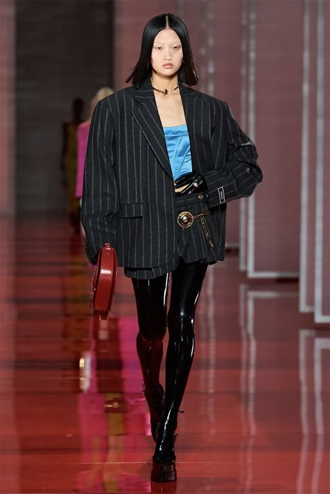 Satin corset top with oversized pinstripe blazer jacket, pleated super mini skirt, oversized medusa pearl belt, latex leggings and platform pumps from the Versace Fall 2022 collection #fashionstyle #ootdstyle Versace Fall 2022, Versace Runway, Fashion Week Trends, Versace Fashion, Donatella Versace, Fall 2022, Looks Vintage, Milan Fashion Week, Runway Fashion