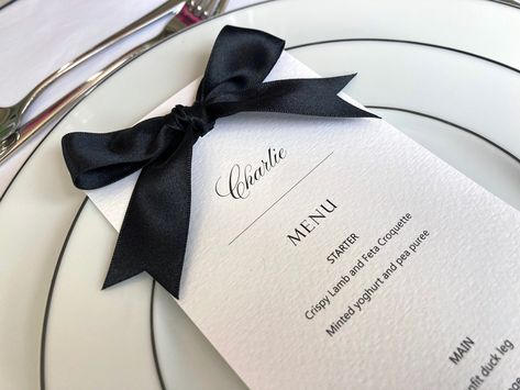 Inform your guests about the delicious meal that lies ahead, with these gorgeous, ribbon detail menu cards. They make a perfect addition to the table decor for a whole host of occasions from bridal  showers and birthday parties through to rehearsal dinners and weddings. The modern menus are printed onto luxurious Italian textured off white card, and are finished with a pretty, hand tied black satin ribbon bow. Your guest names can be added to each menu if you would like it to double as a place card too!  The 'Fancy' menu title font can be swapped for any of the alternatives shown, as can the colour of the bow - see the ribbon colour chart for the options available. ◾️SIZE 10cm x 21cm (approx) / DL Printed single sided ◾️CUSTOMISATION - INDIVIDUAL MENUS  The menus can be tailored to reflect Black And White Name Card, Black And White Menu Design, Wedding Menu With Bow, Dinner Party Menu Design, Brunch Menu Design, Menu With Name, Black Tie Dinner Party, Luxury Dinner Party, Party Menu Card