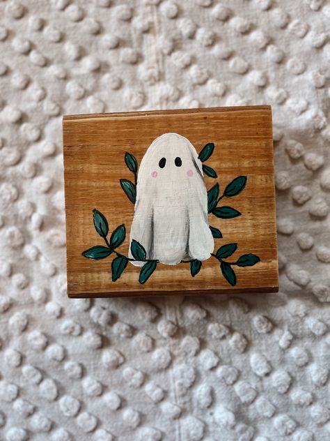 "This hand-painted little ghost wood sign Is perfect for your fall home decor. The wood sign features aa detailed ghost and leaves, making it a unique addition to any room. Make sure to take advantage of this on-of-a-kind decor piece for your home this season measures approximately 6\"x6\" each one is hand-painted meaning there will be slight differences in each one." Diy Fall Decor Painting, Hand Painted Fall Signs, Painted Wood Projects, Small Halloween Canvas Paintings, Wood Block Painting Ideas, Diy Halloween Decorations To Sell, Mini Fall Paintings, Cute Ghost Painting Ideas, Fall Wood Blocks