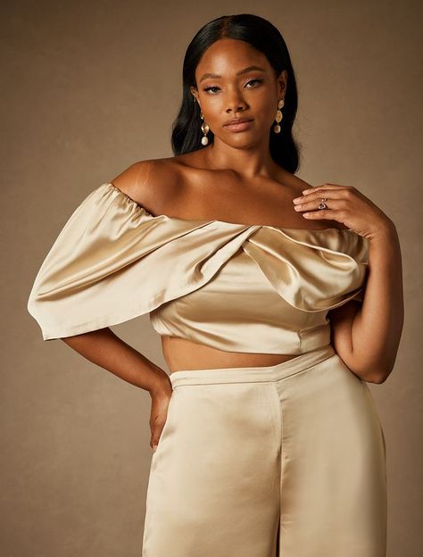 This Bridal by ELOQUII Off The Shoulder Draped Bustier Top - Champagne is one of our Women's Plus Size Dresses from ELOQUII.  Bridal by ELOQUII Off The Shoulder Draped Bustier Top Non-stretch satin Non-stretch lining Off the shoulder Draped sleeve Center back zipper Off the shoulder fitted blouse Crop top Length approx 18" on body (Size 18) Side seams have 1" seam allowance to allow for alterations Bridal styles offer the same fit you know and love from ELOQUII: we recommend ordering the same si Eloquii Bridal, Baroque Aesthetic, Fashion Advice Woman, Artist Ideas, Blouse Crop Top, Blouse Crop, Fitted Blouse, Bridal Styles, Bridal Tops