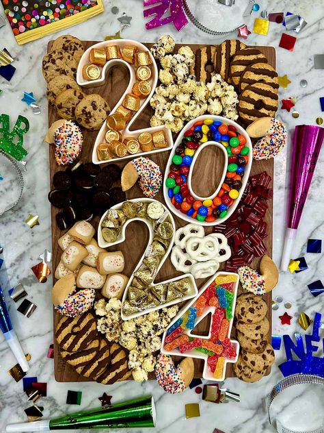 A dessert board with containers in the shapes of the numbers 2024 and candies and treats. New Years Food Board Ideas, Number Candy Charcuterie Board, 2024 Charcuterie Board Numbers, Candy Charcuterie Board Ideas, Nye Drinks, New Years Dinner Party, Nye 2024, Dessert Boards, Holiday Boards