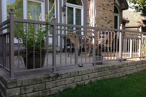 Custom iron railings on a raised patio. Designed and installed by First Fence Company in Hillside, IL. Raised Patio With Railings, Raised Patio Balustrade, Fence Around Concrete Patio, Concrete Patio Railing Ideas, Concrete Patio Railing, Concrete Patio With Railing, Iron Fences And Gates, Pool Fencing Landscaping, Poured Concrete Patio