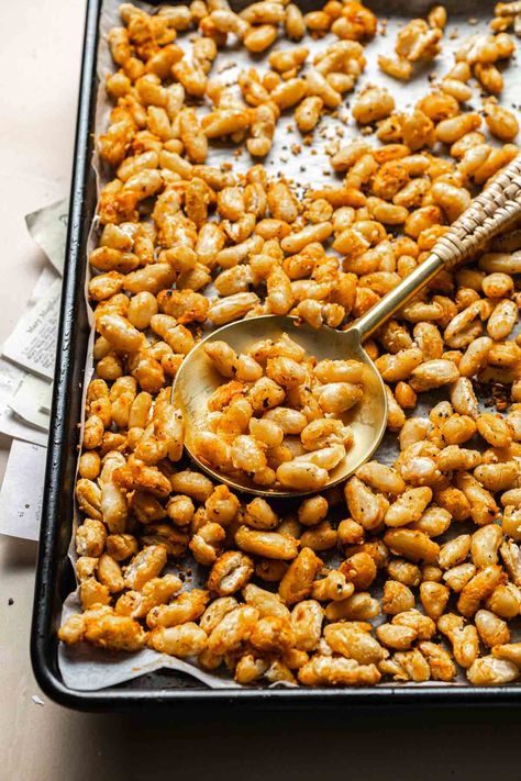 Roasted cannellini beans are a crispy, fiber-rich snack made in just over half an hour. Find out how we turn these creamy white beans into a satisfyingly crunchy snack. This roasted cannellini beans recipe uses pantry staples that you probably already have in your kitchen cupboard. You can serve them as part of your main dish, eat them as a snack or a side. Hint - Think of the seasoning as more of a suggestion rather than a hard rule. If desired, feel free to use your other favorite herbs. Snacks With Beans, Roasted White Beans, Crunchy Beans, Creamy White Beans, Cannellini Beans Recipes, Cannellini Bean, Bean Snacks, Eat Me Drink Me, Northern Beans