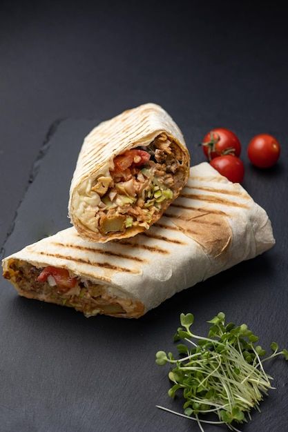 Premium Photo | Shawarma, roll in lavash , grilled meat, with vegetables, sandwich , cut on a black table, horizontal, copy spase Meat With Vegetables, Shawarma Sandwich, Shawarma Ingredients, Shawarma Grill, Chicken Doner, Ramadan Food, Greek Gyros, Doner Kebab, Man Cooking