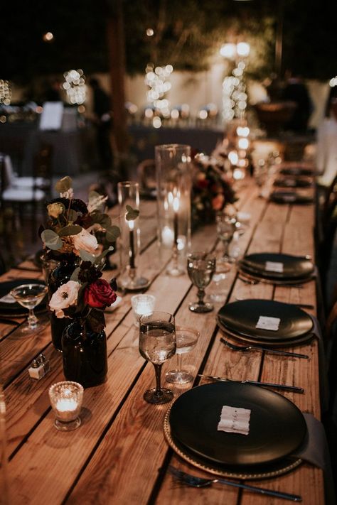 With black decor + bronze accents, the rich colors at this moody table were totally stunning | Image by Jami Laree Black Bridemades Dresses, Moody Wedding Reception Table, Moody Romantic Wedding Decor Table, Moody Garden Party Wedding, Black Simple Wedding Decor, Moody Romantic Wedding Centerpieces, Dark Romantic Wedding Table Decor, Glam Goth Wedding, Simple Moody Wedding Centerpieces