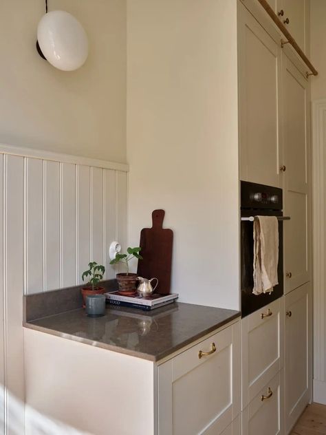 Light beige walls and pops of color in a turn-of-the-century apartment - COCO LAPINE DESIGNCOCO LAPINE DESIGN Turn Of The Century Kitchen, Dark Stone Countertops, Light Beige Walls, Swedish Apartment, Off White Kitchens, Coco Lapine Design, Custom Storage, Turn Of The Century, Beige Walls