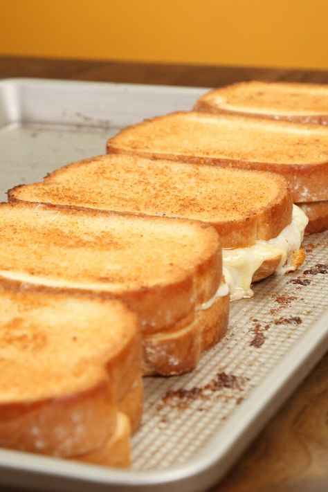 Sheet Pan Grilled Cheese Sandwiches | "This simple sheet pan technique allows you to make five grilled cheeses at the same time! We used 4 types of cheese—goat, white cheddar, provolone, and Swiss—for these buttery, rich sheet pan sandwiches, but feel free to change the cheeses depending on what you like. You could also use toppings, like spinach, basil, and tomato." #sheetpanrecipes #easyrecipes #quickandeasy #easyrecipesideas #dinner #easydinner #easydinnerideas #easysupper #easysupperideas Grilled Cheese For Large Group, Grilled Cheese Sandwiches For A Crowd, Oven Grilled Cheese Baking Sheet, Sheet Pan Grilled Cheese Sandwiches, Grilled Cheese For A Crowd Parties, Oven Baked Grilled Cheese Sandwiches, Sheet Pan Grilled Cheese, Grilled Cheese For A Crowd, Sheet Pan Sandwiches