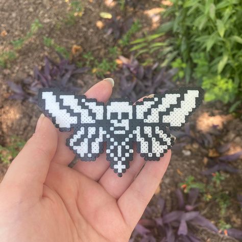 Skull moth made from mini perler beads! (can be made into keychain/necklace/earrings, DM on instagram @feastoncreations to request) Pentagram Perler Beads, Enderman Perler Beads, Perler Bead Skull Patterns, Pearler Bead Halloween Patterns, Slipknot Perler Beads, Hockey Perler Beads, Zombie Perler Bead Patterns, Wednesday Addams Perler Beads, Gothic Perler Beads