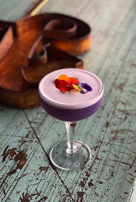 Purple flowery cocktail #purpledrink #purplecocktail #lilac #pretty Purple Cocktail Aesthetic, Wedding Cocktail Bar, Purple Corn, Purple Cocktails, Purple Drinks, Cocktail Names, Best Cocktail Bars, Mocktail Recipes, Cocktail And Mocktail