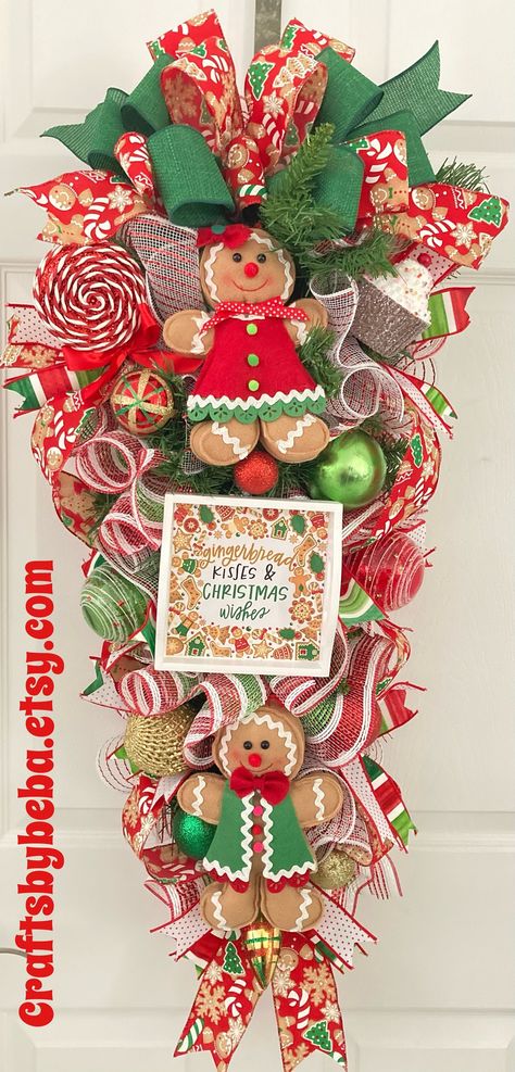 Gingerbread Christmas Swag - Christmas Gingerbread Door Hanger - Handmade Designed on Green Base Decor with Mesh -  Two Cute Girl and Boy Red and Green Felt Gingerbread , Beautiful Matching Bow, Variety Christmas Ornaments , and Wood sign with Christmassy Message " Gingerbread Kisses & Christmas Wishes " ....This Lovely Gingerbread Swag will go Perfect for A Gingerbread Lover Home. Love it Free Shipping Great for a Front Door, Home Entrance, Gift for Someone Special, Farmhouse , School, Office , Mantel , Fireplace.... And more. The Measurement for this Christmas Gingerbread Swag is:  Approximately  13 inches wide  35 inches long  Visit my shop for more variety.... Enjoy Link: Craftsbybeba.etsy.com Hope you found what you were looking for.... Always welcome Looking forward to be part of you Gingerbread Door Hanger, Gingerbread Diy Crafts, Gingerbread Wreaths, Gingerbread Door, Gingerbread Wreath, Hanger Christmas, Felt Gingerbread, Mantel Fireplace, Swag Christmas