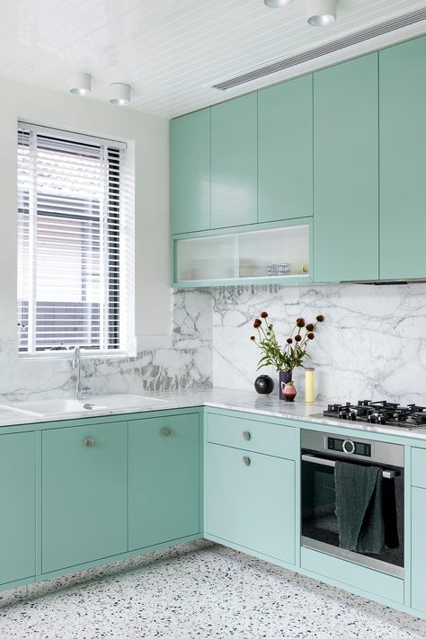 A modern mint green kitchen with Calacatta Statuario countertops, Terrazzo flooring, and white walls and ceiling. Mint Green Kitchen Cabinets, Kitchen Countertops Decor, Mint Green Kitchen, Mint Kitchen, Wood Dining Table Modern, Curved Kitchen, Desain Pantry, Kabinet Dapur, Green Kitchen Cabinets